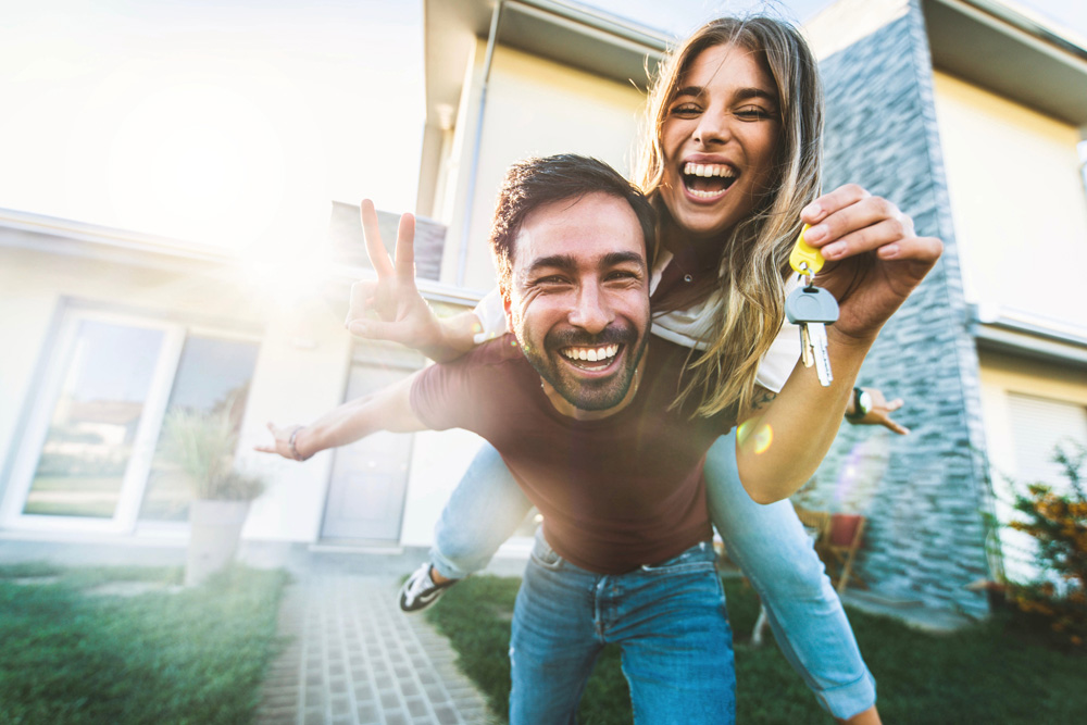 Image of Young couple with the keys to their first home looking very excited